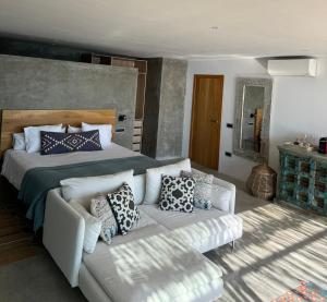 a bedroom with a bed and a couch at El jardin Botánico Villa LUZ in Altea
