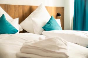 1 dormitorio con 2 camas y almohadas azules y blancas en Hotel Hansa Stuttgart City, en Stuttgart