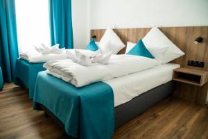 two beds in a hotel room with blue curtains at Hotel Hansa Stuttgart City in Stuttgart