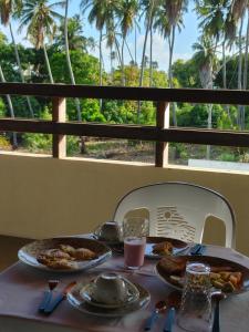 una mesa con dos platos de comida encima en Pousada Viva Praia en Paracuru