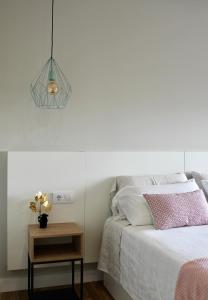 ein Schlafzimmer mit einem Bett und einem Tisch mit einer Lampe in der Unterkunft Altos de Baiona in Baiona