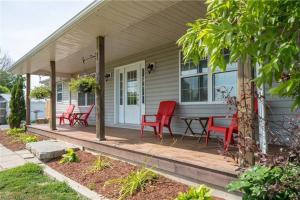 een huis met rode stoelen en een tafel op een veranda bij 2 Bedroom with free parking-upto 10 parking space in Marysville