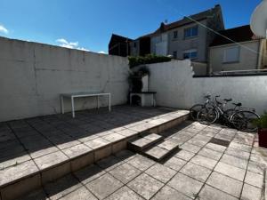 un patio con un banco y 2 bicicletas contra una pared en Villa Quend, 4 pièces, 6 personnes - FR-1-730-6 en Quend