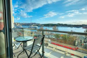 balcón con mesa y vistas al puerto en Cozy 2bedroom seafront apartment, balcony GOSLM-10, en Sliema