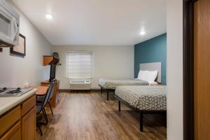 a small room with two beds and a kitchen at WoodSpring Suites Macon North in Macon