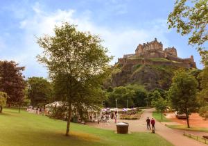 a park with a castle on top of a hill at Luxury apartment, Stafford Street in Edinburgh