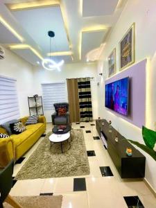 sala de estar con sofá amarillo y TV en Timba ciné02, en Cotonou