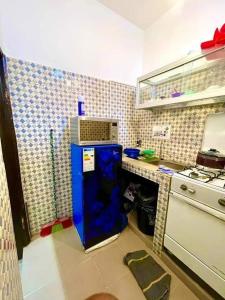 una pequeña cocina con nevera azul en la esquina en Timba ciné02, en Cotonou