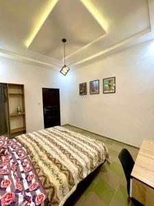 Un dormitorio con una cama y una mesa. en Timba ciné02, en Cotonou
