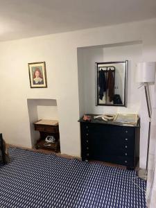 a bedroom with a bed with a dresser and a mirror at Casetta San Donato in Turin