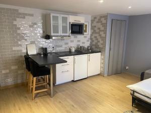 a kitchen with white cabinets and a black counter top at STUDIO VIEILLE VILLE in Nice