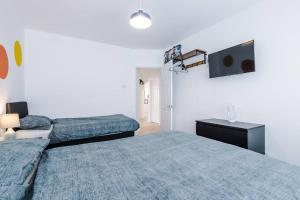 a bedroom with two beds and a flat screen tv at Seaside Serenity: Coastal Charm in Rhyl