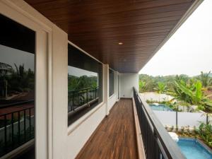 Jade 4BHK Private Pool Villa by Le Pension Stays في أولد غوا: بلكونة منزل مع مسبح