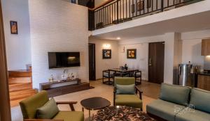 sala de estar con sofá, sillas y TV en Jade 4BHK Private Pool Villa by Le Pension Stays en Old Goa