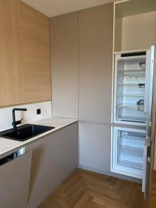 a kitchen with an empty refrigerator and a sink at Bratislava FORESTPARK, FREE parking, self-check IN in Bratislava