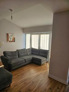 a living room with a gray couch and wooden floors at Cozy 2 Bedroom Apartment in Kilkenny