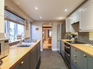 una cucina con un lavello e un piano di lavoro di Clematis Cottage a Belper