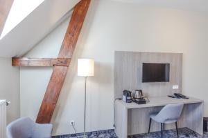 レーワルデンにあるフレッチャー ホテル パレ スタッドホウデルリーク ホフのデスク、椅子2脚、テレビが備わる客室です。