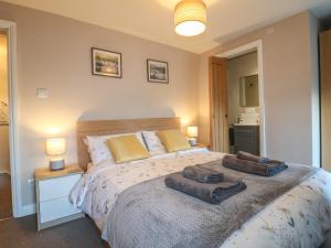 a bedroom with a bed with two towels on it at Clematis Cottage in Belper