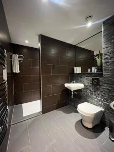 a bathroom with a toilet and a sink and a shower at Tunnage Square Apartments Duke St by EPIC in Liverpool