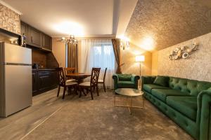 a living room with a green couch and a table at Torres Poiana Boutique in Poiana Brasov