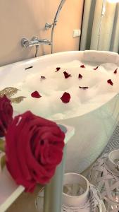 a red rose on the side of a bath tub at Elegante Apartments Władysławowo in Władysławowo