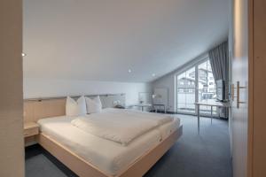 1 dormitorio con cama grande y ventana grande en Petit madlein, en Ischgl