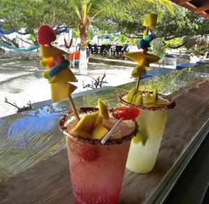 two cocktails sitting on a window sill with a view of the beach at HOTEL CASA BLANCA in Necoclí