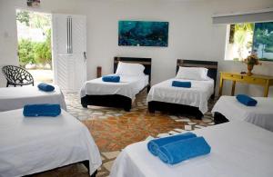 a room with four beds with blue towels on them at HOTEL CASA BLANCA in Necoclí