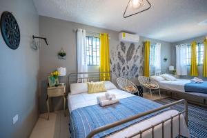 a bedroom with two beds and yellow curtains at Rustic Raspuru in St Mary