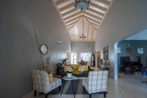 a living room with a couch and two chairs at Rustic Raspuru in St Mary