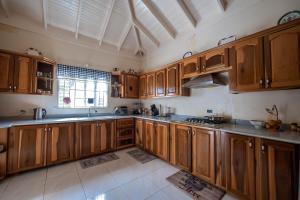 a large kitchen with wooden cabinets and a window at Rustic Raspuru in St Mary