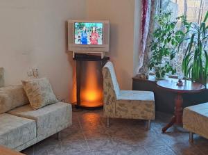 a living room with a couch and a tv at Vila Dedo Liben in Vratsa