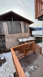 a wooden deck in front of a house in the snow at Apartment Goldener Schnee Tesero in Tesero