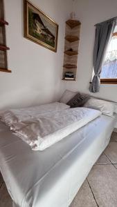 uma grande cama branca num quarto com uma janela em Apartment Goldener Schnee Tesero em Tesero