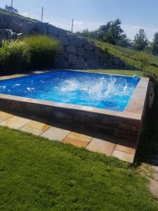 a swimming pool in a yard with a stone wall at Unterbrandlberg in Steinbach an der Steyr