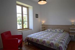 een slaapkamer met een bed en een rode stoel bij Villa : Les Embruns classé 4 étoiles in Bréhat