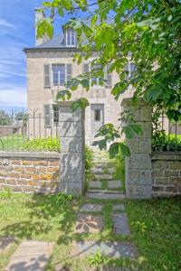 kamienny dom z ceglaną ścianą i drzewem w obiekcie Villa : Les Embruns classé 4 étoiles w mieście Bréhat