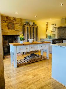 cocina con mesa en el centro de una habitación en Campden Mews, en Chipping Campden 27 fotos más