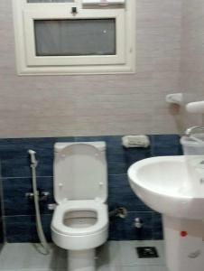 a bathroom with a toilet and a sink at Pyramids and Museum Resort Apartment in Giza