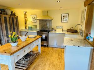 a kitchen with white counters and a stove top oven at Campden Mews in Chipping Campden +23 photos