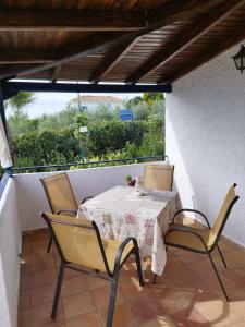 a table and chairs on a balcony with a view at Giannis House 2 minutes walk to the beach Peroulia in Kómboi