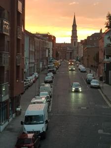 una calle de la ciudad con coches aparcados y una torre del reloj en Spacious City Centre Apt - O'Connell Street Area en Dublín