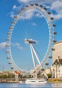 a large ferris wheel in the middle of the water at Spacious Room with City Skyline Views close to London Eye in London