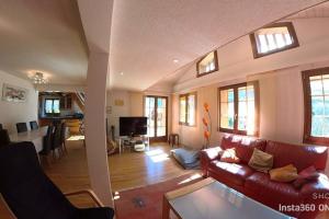 a living room with a red couch and a table at Stecaya Face à la piste de l'Aigle in Zinal