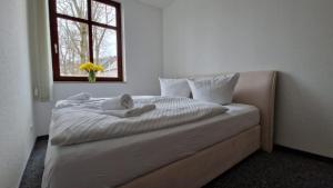 1 dormitorio con 1 cama blanca y ventana en Markt 9 Appartements Oberwiesenthal, en Kurort Oberwiesenthal