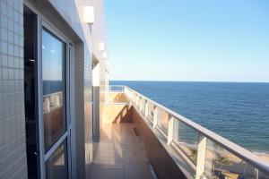 a balcony of a building with a view of the ocean at Praia Amaralina Pituba Estúdio Perfeito Smart in Salvador