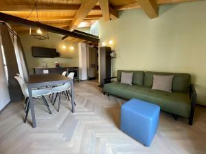 een woonkamer met een groene bank en een tafel bij Saragozza Suite 7 Attico con altana a due passi da Piazza Grande WIFI e parcheggio gratuito in Modena