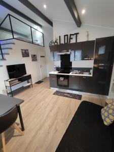 a living room with a staircase and a living room with a table at Loft and Studio and Love Room in Bourg-Saint-Christophe