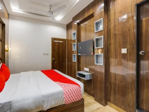 1 dormitorio con 1 cama y pared de madera en OYO Hotel bhanu Villa, en Ahmedabad